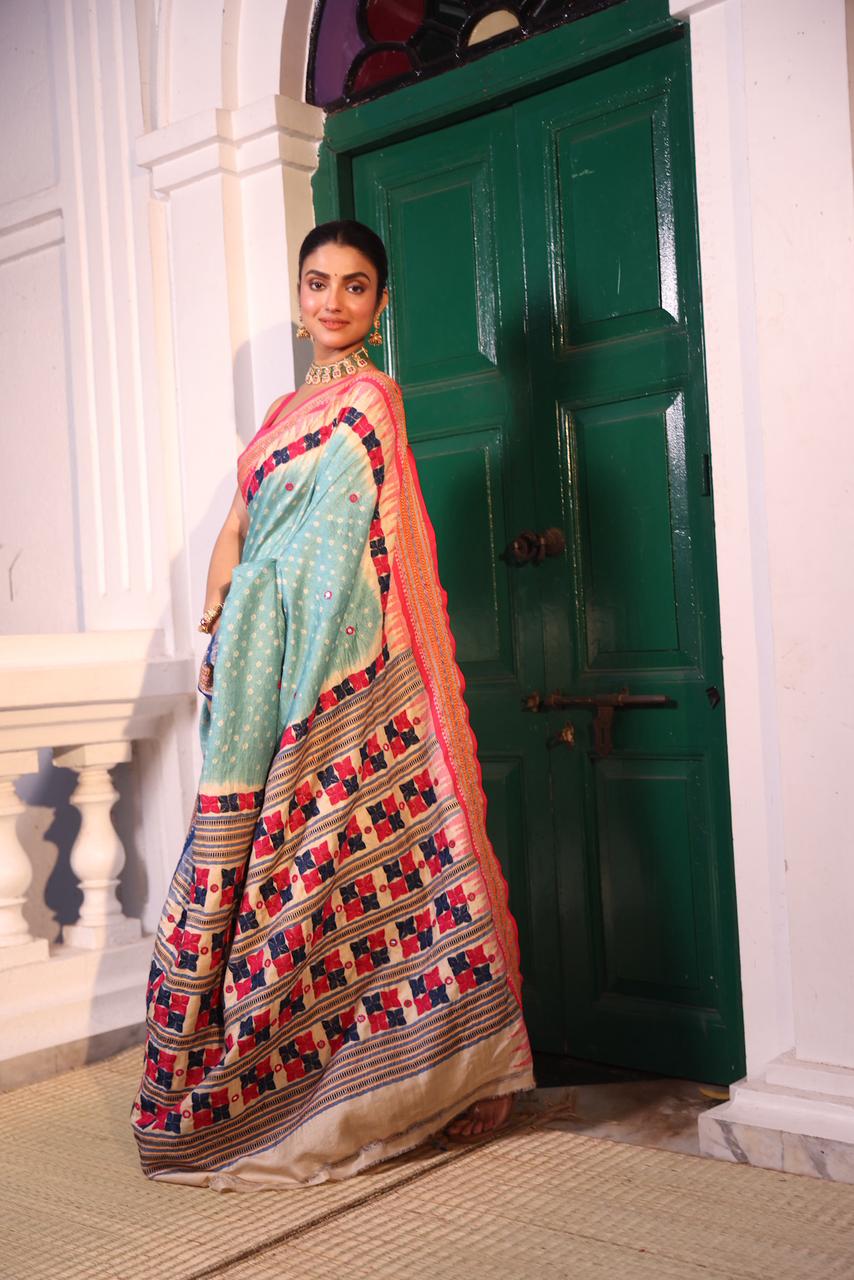 An exquisite handwoven vidharbha tussar silk saree with karvati kinar border intricately tie dyed with turquoise blue bhandhej and phulkari hand embroidered