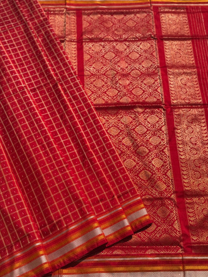 A masterpiece piece red shade weft single ikkat tie dyed handwoven saree in pure mulberry silk with traditional checks