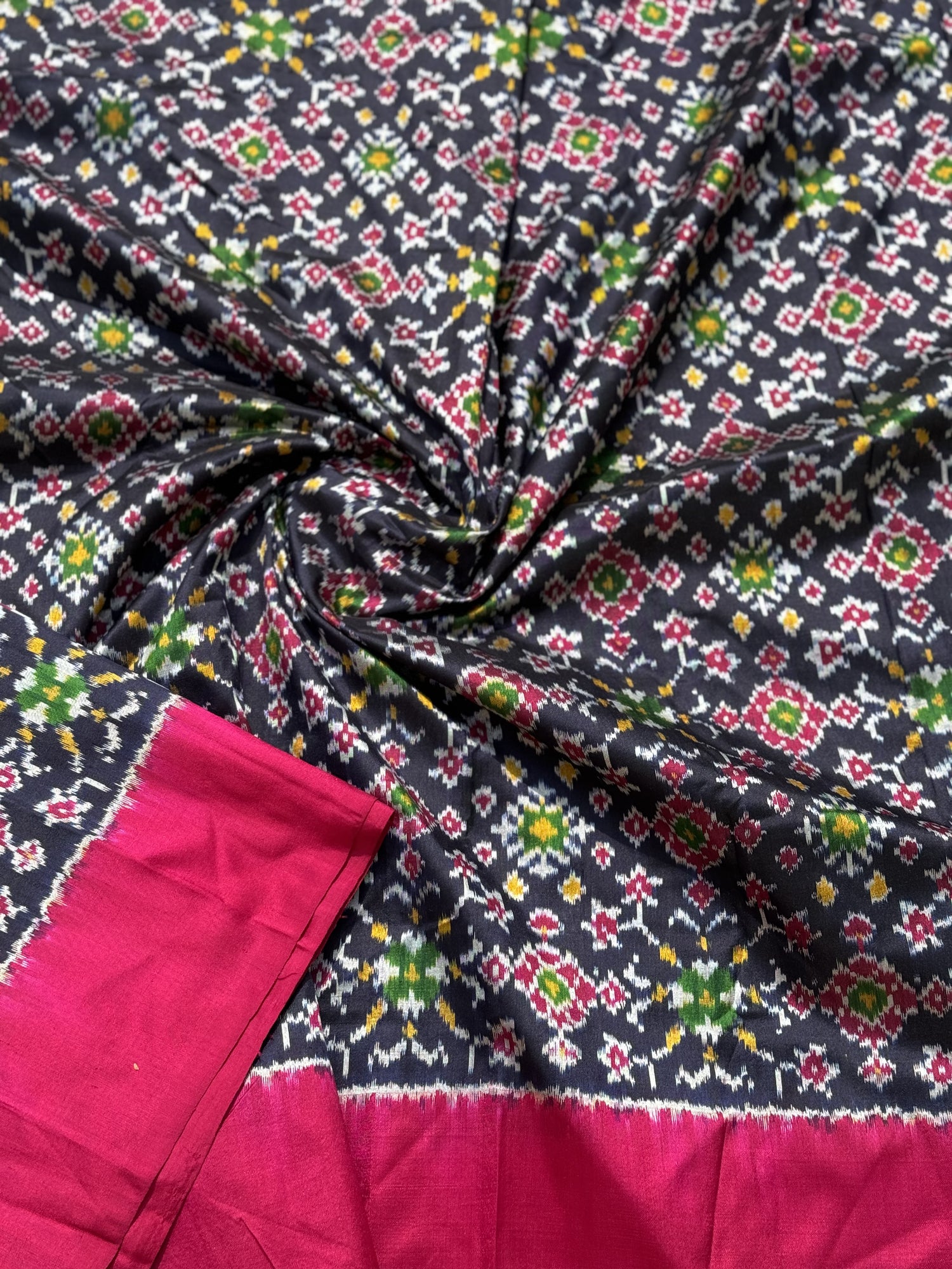 Black with pink patola inspired navratan ikkat design on pure mulberry silk fabric